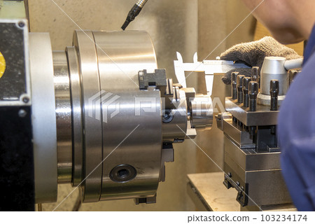 Close up scene the machine operator measuring the dimension the metal shaft parts by dial Vernier caliper. Close up scene the machine operator measuring the dimension the metal shaft parts by dial Vernier caliper. 103234174