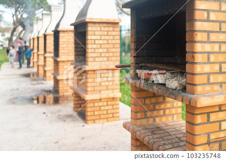 Barbecue fireplace with stack of chopped firewood in park Barbecue fireplace with stack of chopped firewood in park 103235748