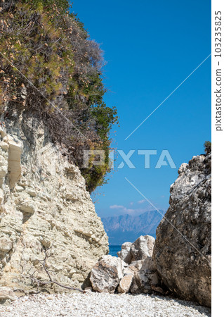 White rocks vertical cliff with greenery, Greece White rocks vertical cliff with greenery, Greece 103235825
