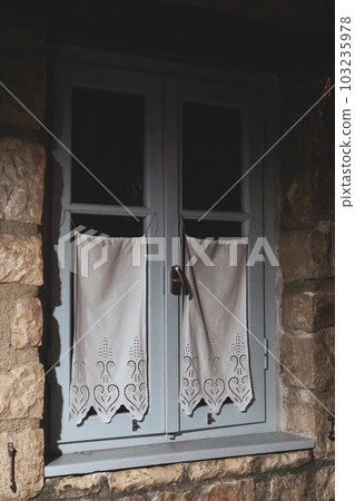 Blue window with white curtains in stone interior 103235978