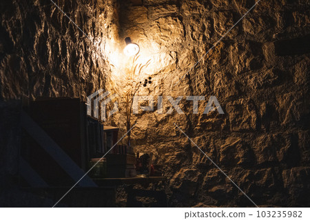 Warm cozy lamp in corner on bookshelf in dark room Warm cozy lamp in corner on bookshelf in dark room 103235982