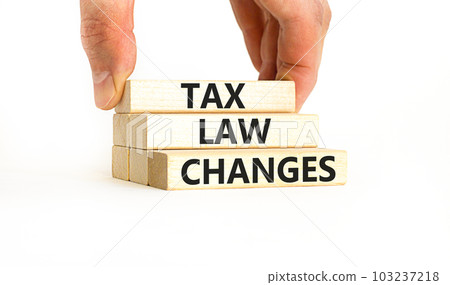 Tax law changes symbol. Concept words Tax law changes on wooden blocks on a beautiful white table white background. Businessman hand. Business tax law changes concept. Copy space. Tax law changes symbol. Concept words Tax law changes on wooden blocks on a beautiful white table white background. Businessman hand. Business tax law changes concept. Copy space. 103237218