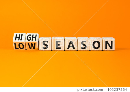 High or low season symbol. Concept words High season and Low season on wooden cubes. Beautiful orange table orange background. Business high or low season concept. Copy space. 103237264