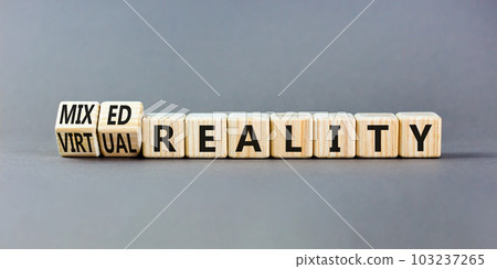 Mixed or virtual reality symbol. Concept words Mixed reality Virtual reality on wooden cubes. Beautiful grey table grey background. Business mixed or virtual reality concept. Copy space. Mixed or virtual reality symbol. Concept words Mixed reality Virtual reality on wooden cubes. Beautiful grey table grey background. Business mixed or virtual reality concept. Copy space. 103237265