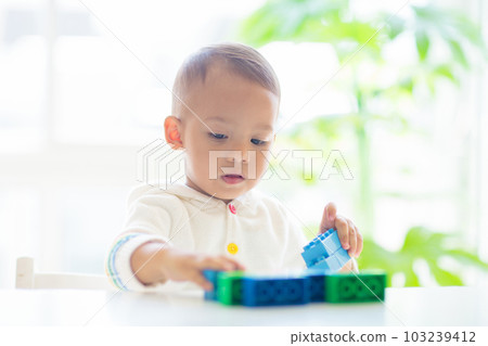 Baby boy playing with toy 103239412