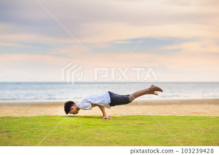 Teenager doing calisthenics exercise. Beach yoga. Teenager doing calisthenics exercise. Beach yoga. 103239428