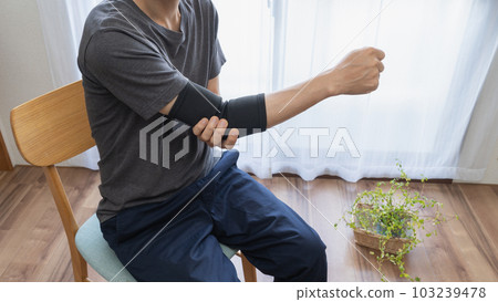 Man with elbow support | Joint pain image Man with elbow support | Joint pain image 103239478