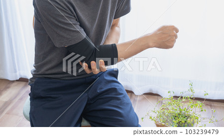 Man with elbow support | Joint pain image Man with elbow support | Joint pain image 103239479