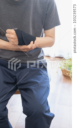 A man with a wrist/thumb supporter 103239573