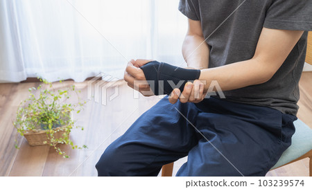 A man with a wrist/thumb supporter 103239574