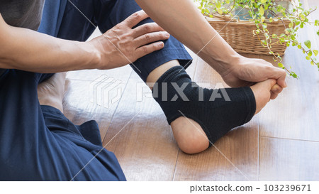 A man who supports his ankle 103239671