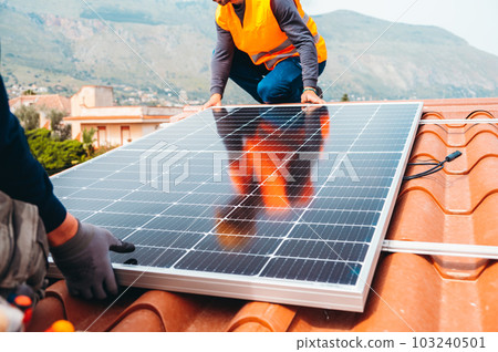 Workers assemble energy system with solar panel for electricity and hot water 103240501