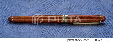 retro, elegant, rosewood ballpoint pen on a textured bark paper retro, elegant, rosewood ballpoint pen on a textured bark paper 103240658