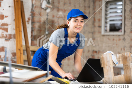 Woman with laptop on indoor construction site 103241116
