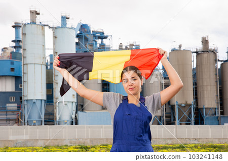 Calm young woman worker with flag of Belgium against background of factory 103241148