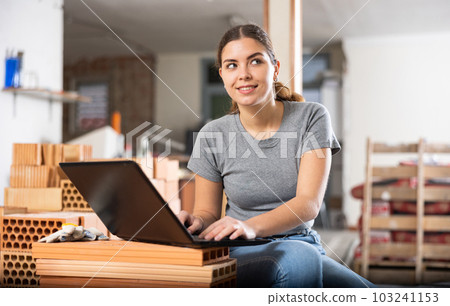 Woman with laptop on indoor construction site 103241153