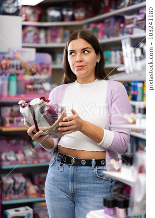 Young woman chooses set of gifts for someone in cosmetics store 103241180