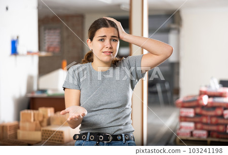 Portrait of frustrated woman standing in apartment Portrait of frustrated woman standing in apartment 103241198