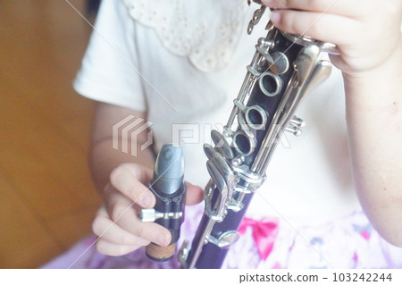 A girl building a clarinet. A girl who has just joined the brass band club. 103242244