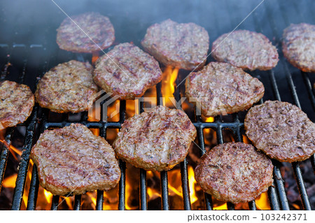 On hot grill flame an American beef burger is grilled to perfection 103242371