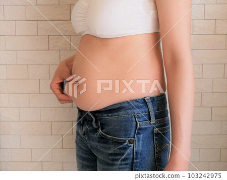 A young woman who is worried about her stomach 103242975