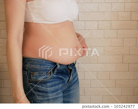 A young woman who is worried about her stomach 103242977