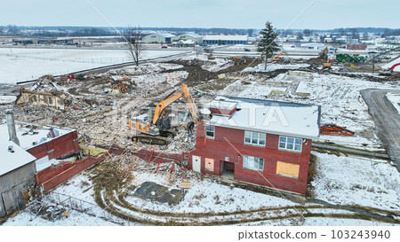 Aerial of tire tracks through snow at a construction site involving tearing down an old building Aerial of tire tracks through snow at a construction site involving tearing down an old building 103243940