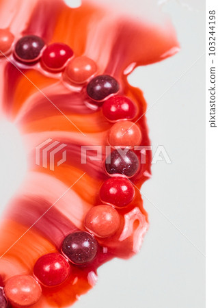 Red and pink and purple skittles candy leaks rainbow valentines day colors through water on a place background asset 103244198