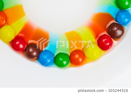 Smile of rainbow colors from skittles candy mixing with water on white background 103244328