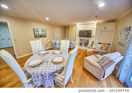 Living room with beige hard wood floors dining room table set, couches, TV, fireplace, and lazy boy Living room with beige hard wood floors dining room table set, couches, TV, fireplace, and lazy boy 103244749