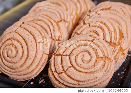 Chocolate or cinnamon conchas baked goods Mexican sweet bread on black tray Chocolate or cinnamon conchas baked goods Mexican sweet bread on black tray 103244905