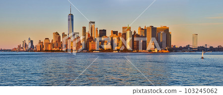 Stunning golden light over southern Manhattan panoramic skyline from waters 103245062