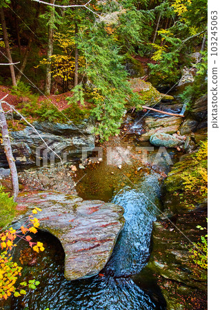 Stunning gorge from above with rocks covered in fall leaves and colorful forest 103245063