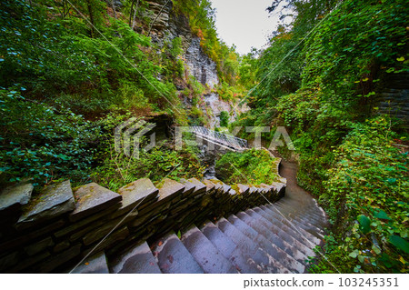View looking down stone step trail in woods leading to bridge in New York View looking down stone step trail in woods leading to bridge in New York 103245351