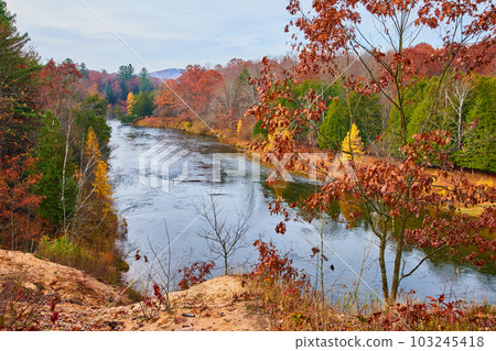 River in Michigan's late fall with colorful foliage and green pines River in Michigan's late fall with colorful foliage and green pines 103245418