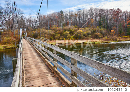 Suspension bridge in Michigan crosses over river in late fall Suspension bridge in Michigan crosses over river in late fall 103245540