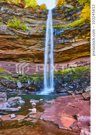 Stunning tall waterfall cliffs from below crashing into rocks Stunning tall waterfall cliffs from below crashing into rocks 103245653