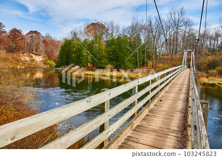 Manistee River Trail suspension bridge in late fall over river Manistee River Trail suspension bridge in late fall over river 103245823