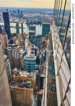 High in skyscraper showing outside walls and overlooking New York City skyline in soft morning light 103246015