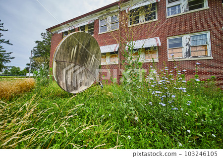 Overgrown fields surround satellite dish and abandoned brick building Overgrown fields surround satellite dish and abandoned brick building 103246105