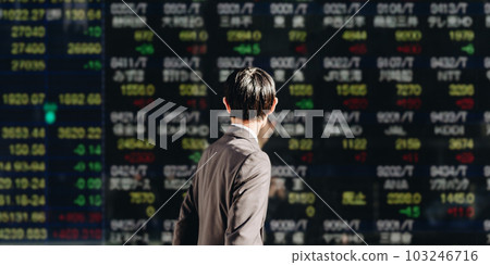 路人商人看著商業區電子公告牌上顯示的股價牌 103246716