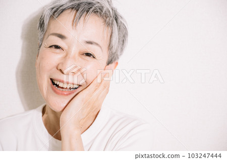 微笑的灰髮女人撫摸她的臉頰，護膚形象 103247444