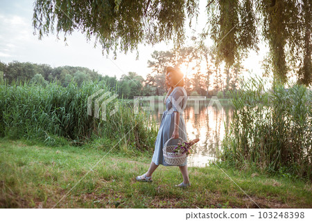 A young woman going on a picnic in a park A young woman going on a picnic in a park 103248398