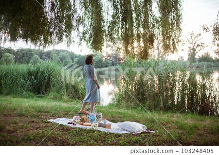 A young woman going on a picnic in a park A young woman going on a picnic in a park 103248405
