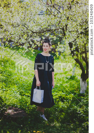 Happy woman walking in the spring cherry garden Happy woman walking in the spring cherry garden 103248409