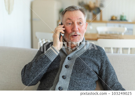 Happy middle aged senior man talking on smartphone with family friends. Older mature grandfather with cell phone talking with grown up children, resting at home. Older generation modern tech usage Happy middle aged senior man talking on smartphone with family friends. Older mature grandfather with cell phone talking with grown up children, resting at home. Older generation modern tech usage 103249025