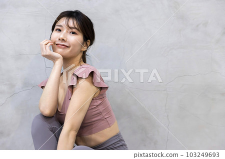 Young woman sitting in yoga clothes 103249693