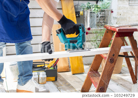 A man who works hard on DIY on the veranda A man who works hard on DIY on the veranda 103249729