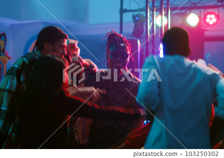Diverse people waltzing in nightclub, attending cool party with friends at discotheque. Young couples dancing in pairs on romantic music, showing off slow dance moves on dance floor. Tripod shot. 103250302