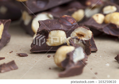 Pieces of homemade milk chocolate with lots of hazelnuts Pieces of homemade milk chocolate with lots of hazelnuts 103250610